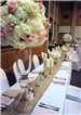 Pastel wedding reception head table with peach and white roses and pastel center pieces