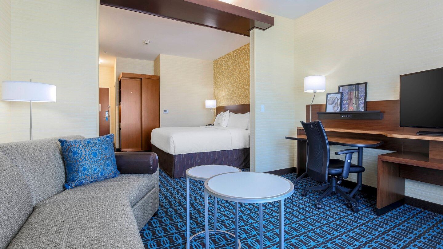 King Suite living room area with a couch and work desk looking at the bed