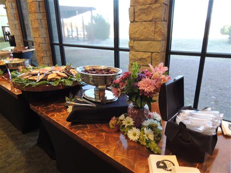 Wedding reception Buffett tables with food and flowers in front of windows